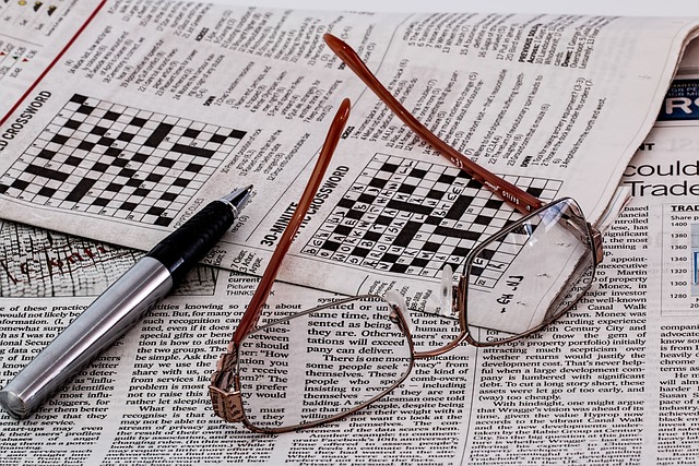 A table with a crossword puzzle book, pencil, and eraser. The book is open to a partially completed puzzle, with some squares filled in